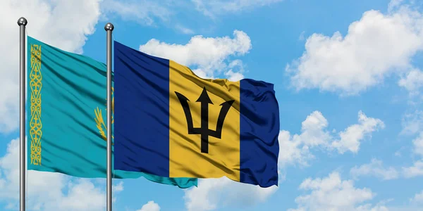 Bandera de Kazajstán y Barbados ondeando en el viento contra el cielo azul nublado blanco juntos. Concepto diplomático, relaciones internacionales . — Foto de Stock