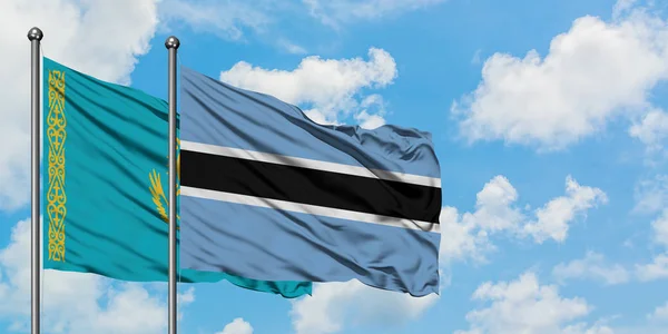 Kazahsztán és Botswana zászló integetett a szél ellen, fehér felhős kék ég együtt. Diplomáciai koncepció, nemzetközi kapcsolatok. — Stock Fotó