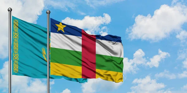 Bandera de Kazajstán y República Centroafricana ondeando en el viento contra el cielo azul nublado blanco juntos. Concepto diplomático, relaciones internacionales . — Foto de Stock