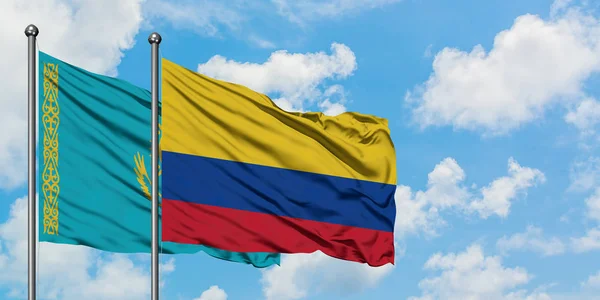 Cazaquistão e Colômbia acenando com a bandeira no vento contra o céu azul nublado branco juntos. Conceito de diplomacia, relações internacionais . — Fotografia de Stock