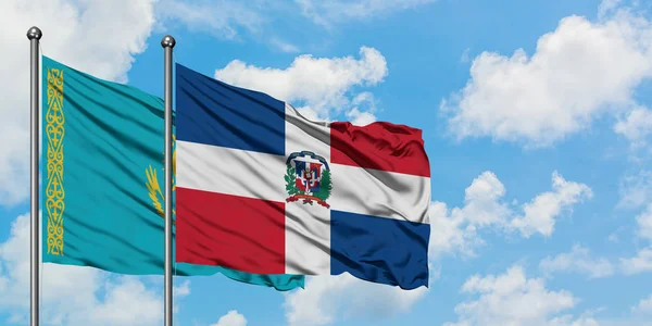 Bandera de Kazajstán y República Dominicana ondeando en el viento contra el cielo azul nublado blanco juntos. Concepto diplomático, relaciones internacionales . — Foto de Stock