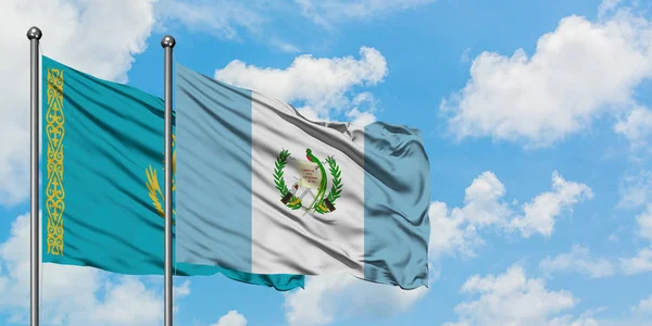 Bandera de Kazajstán y Guatemala ondeando en el viento contra el cielo azul nublado blanco juntos. Concepto diplomático, relaciones internacionales . — Foto de Stock