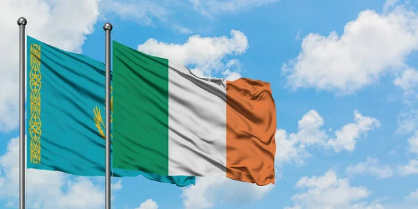 Kazakstan och Irland flagga vinka i vinden mot vit grumlig blå himmel tillsammans. Diplomatisk koncept, internationella relationer. — Stockfoto