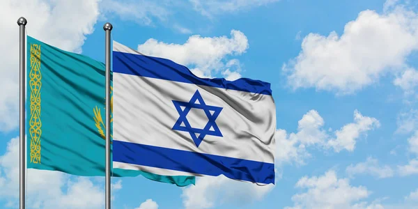 Bandera de Kazajstán e Israel ondeando en el viento contra el cielo azul nublado blanco juntos. Concepto diplomático, relaciones internacionales . — Foto de Stock