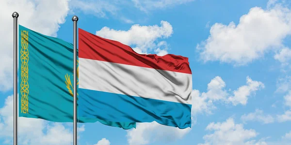 Kazachstan i Luksemburg flaga machając w wiatr przed białym zachmurzone błękitne niebo razem. Koncepcja dyplomacji, stosunki międzynarodowe. — Zdjęcie stockowe