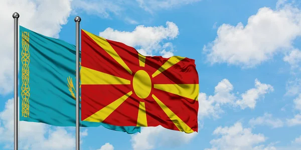 Bandera de Kazajstán y Macedonia ondeando en el viento contra el cielo azul nublado blanco juntos. Concepto diplomático, relaciones internacionales . — Foto de Stock