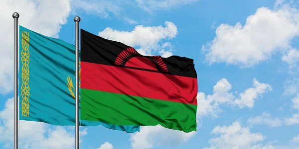 Bandera de Kazajstán y Malawi ondeando en el viento contra el cielo azul nublado blanco juntos. Concepto diplomático, relaciones internacionales . — Foto de Stock