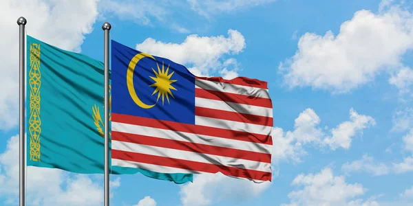 哈萨克斯坦和马来西亚国旗在风中飘扬，与白云蓝天相一起。外交概念、国际关系. — 图库照片