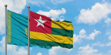 Kazakistan ve Togo bayrağı birlikte beyaz bulutlu mavi gökyüzüne karşı rüzgarsal sallayarak. Diplomasi kavramı, uluslararası ilişkiler.