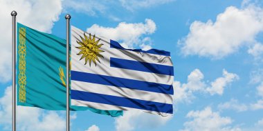 Kazakistan ve Uruguay bayrağı birlikte beyaz bulutlu mavi gökyüzüne karşı rüzgarsal sallayarak. Diplomasi kavramı, uluslararası ilişkiler.