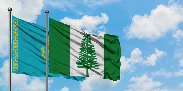 Kasachstan und Norfolk Island Flagge wehen im Wind vor weißem wolkenlosem blauen Himmel zusammen. Diplomatie-Konzept, internationale Beziehungen. — Stockfoto