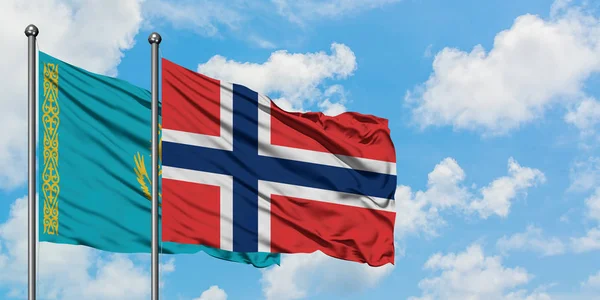 Bandera de Kazajstán y Noruega ondeando en el viento contra el cielo azul nublado blanco juntos. Concepto diplomático, relaciones internacionales . — Foto de Stock