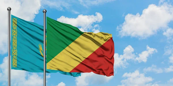 Drapeau du Kazakhstan et de la République du Congo agitant dans le vent contre le ciel bleu nuageux blanc ensemble. Concept de diplomatie, relations internationales . — Photo