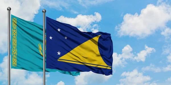 Bandera de Kazajstán y Tokelau ondeando en el viento contra el cielo azul nublado blanco juntos. Concepto diplomático, relaciones internacionales . — Foto de Stock