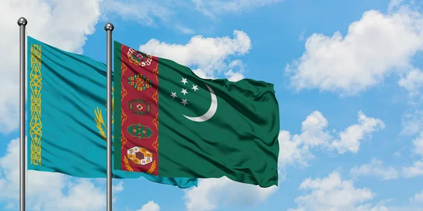 Kazachstán a Turkmenistán vlají ve větru proti bíle zatažené modré obloze. Diplomacie, mezinárodní vztahy. — Stock fotografie