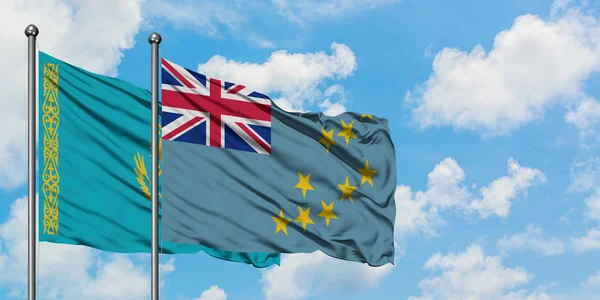 Bandera de Kazajstán y Tuvalu ondeando en el viento contra el cielo azul nublado blanco juntos. Concepto diplomático, relaciones internacionales . — Foto de Stock