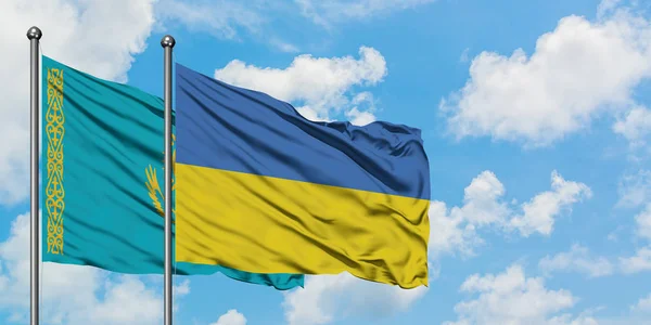 Kazachstán a ukrajinská vlajka mávali ve větru proti bíle zatažené modré obloze. Diplomacie, mezinárodní vztahy. — Stock fotografie