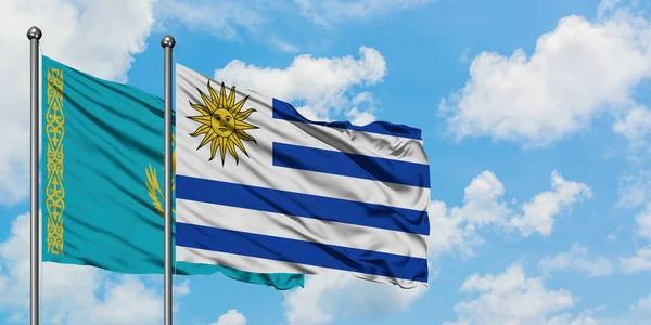 Kazakistan ve Uruguay bayrağı birlikte beyaz bulutlu mavi gökyüzüne karşı rüzgarsal sallayarak. Diplomasi kavramı, uluslararası ilişkiler.