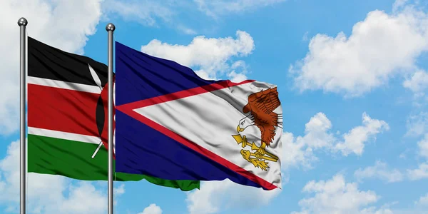 Kenya ve Amerikan Samoası bayrağı birlikte beyaz bulutlu mavi gökyüzüne karşı rüzgarda sallayarak. Diplomasi kavramı, uluslararası ilişkiler. — Stok fotoğraf