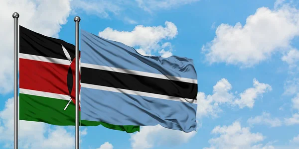 Kenya és Botswana zászló integetett a szél ellen, fehér felhős kék ég együtt. Diplomáciai koncepció, nemzetközi kapcsolatok. — Stock Fotó