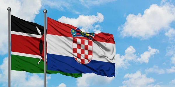 Quênia e Croácia bandeira acenando no vento contra o céu azul nublado branco juntos. Conceito de diplomacia, relações internacionais . — Fotografia de Stock