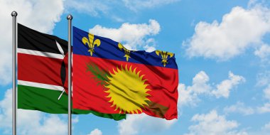 Kenya ve Guadeloupe bayrağı birlikte beyaz bulutlu mavi gökyüzüne karşı rüzgarda sallayarak. Diplomasi kavramı, uluslararası ilişkiler.