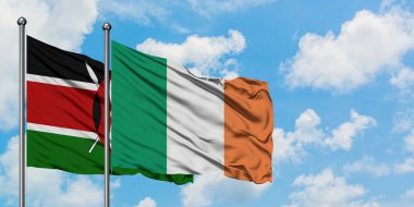 Kenya ve İrlanda bayrağı birlikte beyaz bulutlu mavi gökyüzüne karşı rüzgarda sallayarak. Diplomasi kavramı, uluslararası ilişkiler.