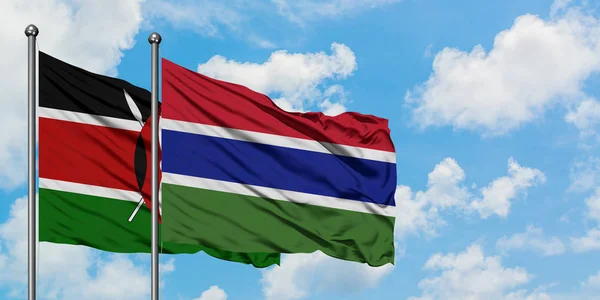 Kenya e Gambia sventolano insieme la bandiera contro il cielo azzurro nuvoloso bianco. Concetto di diplomazia, relazioni internazionali . — Foto Stock