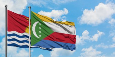 Kiribati ve Komorbayrağı birlikte beyaz bulutlu mavi gökyüzüne karşı rüzgarda sallayarak. Diplomasi kavramı, uluslararası ilişkiler.