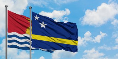 Kiribati ve Curacao bayrak birlikte beyaz bulutlu mavi gökyüzüne karşı rüzgarda sallayarak. Diplomasi kavramı, uluslararası ilişkiler.
