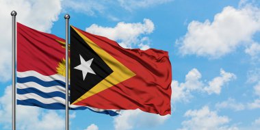 Kiribati ve Doğu Timor bayrağı birlikte beyaz bulutlu mavi gökyüzüne karşı rüzgarda sallayarak. Diplomasi kavramı, uluslararası ilişkiler.