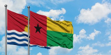 Kiribati ve Gine Bissau bayrağı birlikte beyaz bulutlu mavi gökyüzüne karşı rüzgarda sallayarak. Diplomasi kavramı, uluslararası ilişkiler.