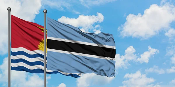 Bandera de Kiribati y Botswana ondeando en el viento contra el cielo azul nublado blanco juntos. Concepto diplomático, relaciones internacionales . — Foto de Stock
