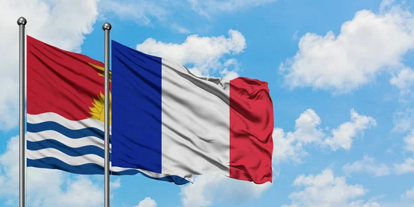 Kiribati y la bandera de Francia ondeando en el viento contra el cielo azul nublado blanco juntos. Concepto diplomático, relaciones internacionales . — Foto de Stock