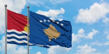 Kiribati ve Kosova bayrağı birlikte beyaz bulutlu mavi gökyüzüne karşı rüzgarda sallayarak. Diplomasi kavramı, uluslararası ilişkiler.