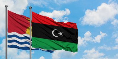 Kiribati ve Libya bayrağı birlikte beyaz bulutlu mavi gökyüzüne karşı rüzgarda sallayarak. Diplomasi kavramı, uluslararası ilişkiler.