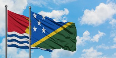 Kiribati ve Solomon Adaları bayrağı birlikte beyaz bulutlu mavi gökyüzüne karşı rüzgarda sallayarak. Diplomasi kavramı, uluslararası ilişkiler.