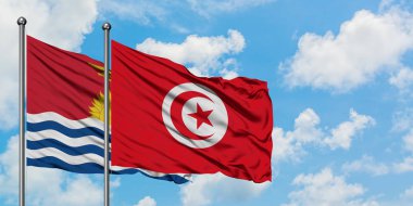 Kiribati ve Tunus bayrağı birlikte beyaz bulutlu mavi gökyüzüne karşı rüzgarda sallayarak. Diplomasi kavramı, uluslararası ilişkiler.