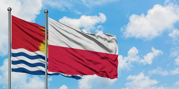 Kiribati y la bandera de Polonia ondeando en el viento contra el cielo azul nublado blanco juntos. Concepto diplomático, relaciones internacionales . — Foto de Stock
