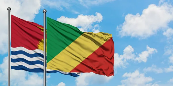 Kiribati y la bandera de la República del Congo ondeando en el viento contra el cielo azul nublado blanco juntos. Concepto diplomático, relaciones internacionales . — Foto de Stock