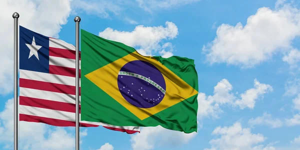 ไลบีเรียและบราซิลโบกธงในลมกับท้องฟ้าสีขาวเมฆสีฟ้าร่วมกัน แนวคิดทางการทูต ความสัมพันธ์ระหว่างประเทศ . — ภาพถ่ายสต็อก