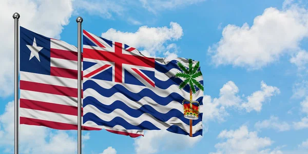 Ліберії та британської території Індійського океану прапор розмахуючи в вітер проти білого хмарного синього неба разом. Концепція дипломатії, міжнародні відносини. — стокове фото