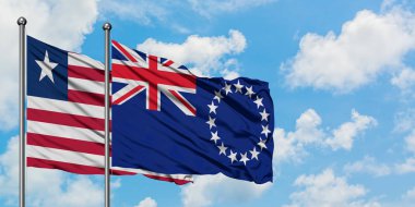 Liberya ve Cook Adaları bayrağı birlikte beyaz bulutlu mavi gökyüzüne karşı rüzgarda sallayarak. Diplomasi kavramı, uluslararası ilişkiler.