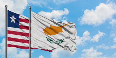 Liberya ve Kıbrıs bayrağı birlikte beyaz bulutlu mavi gökyüzüne karşı rüzgarda sallayarak. Diplomasi kavramı, uluslararası ilişkiler.