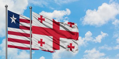 Liberya ve Gürcistan bayrağı birlikte beyaz bulutlu mavi gökyüzüne karşı rüzgarda sallayarak. Diplomasi kavramı, uluslararası ilişkiler.