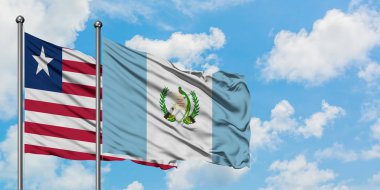 Liberya ve Guatemala bayrağı birlikte beyaz bulutlu mavi gökyüzüne karşı rüzgarda sallayarak. Diplomasi kavramı, uluslararası ilişkiler.