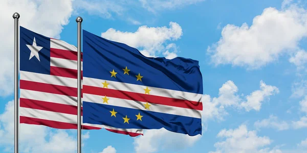 Liberia ja Kap Verde lippu heiluttavat tuulessa yhdessä valkoista pilvistä sinistä taivasta vasten. Diplomatian käsite, kansainväliset suhteet . — kuvapankkivalokuva