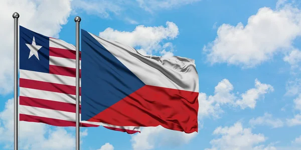 Libérie a Česká republika vlnící se ve větru proti bíle zatažené modré obloze. Diplomacie, mezinárodní vztahy. — Stock fotografie