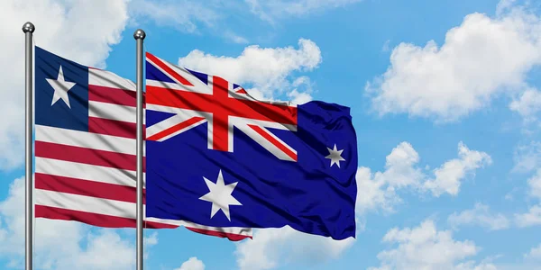 Liberia und hörte Insel und mcdonald Islands Flagge wehen im Wind vor weißem wolkenlosem blauen Himmel zusammen. Diplomatie-Konzept, internationale Beziehungen. — Stockfoto