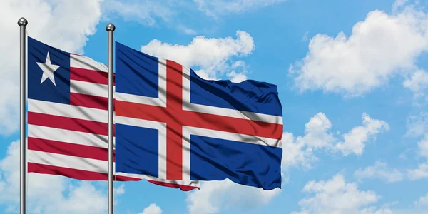 Bandera de Liberia e Islandia ondeando en el viento contra el cielo azul nublado blanco juntos. Concepto diplomático, relaciones internacionales . — Foto de Stock